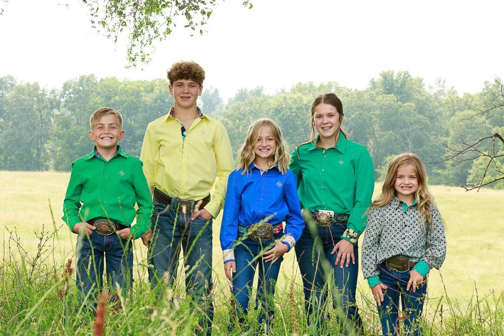 A group of kids in a hayfield wearing Detail Dive custom show shirts and jeans.